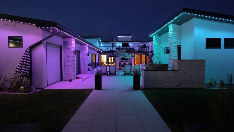 A pool and patio lit in warm white