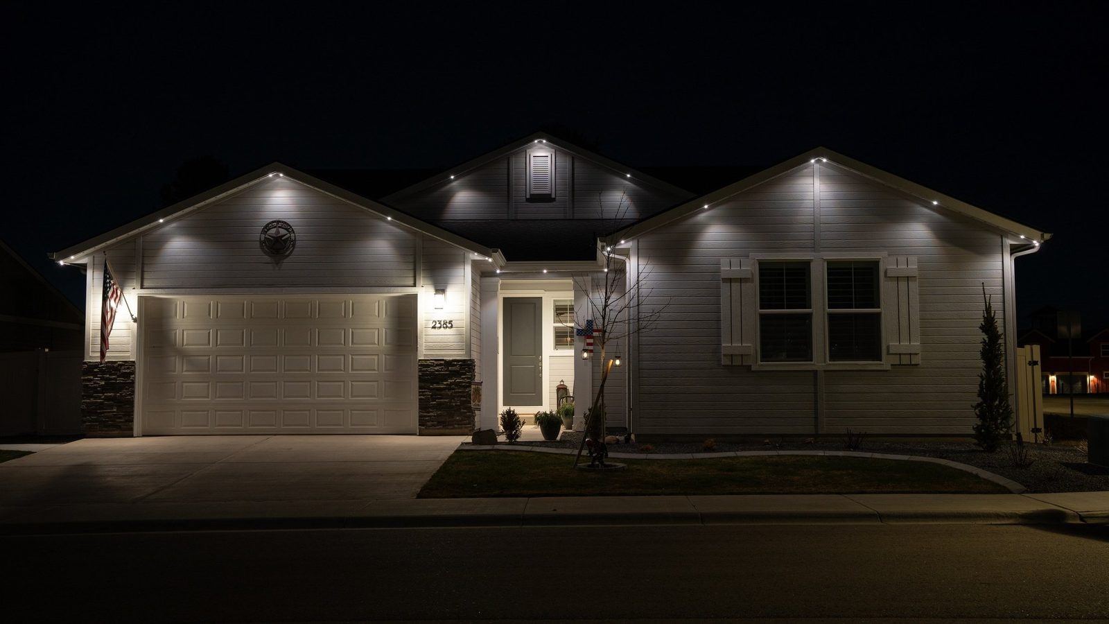 A two-story home lit in warm white